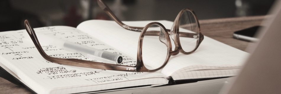 eyeglasses with gray frames on the top of notebook